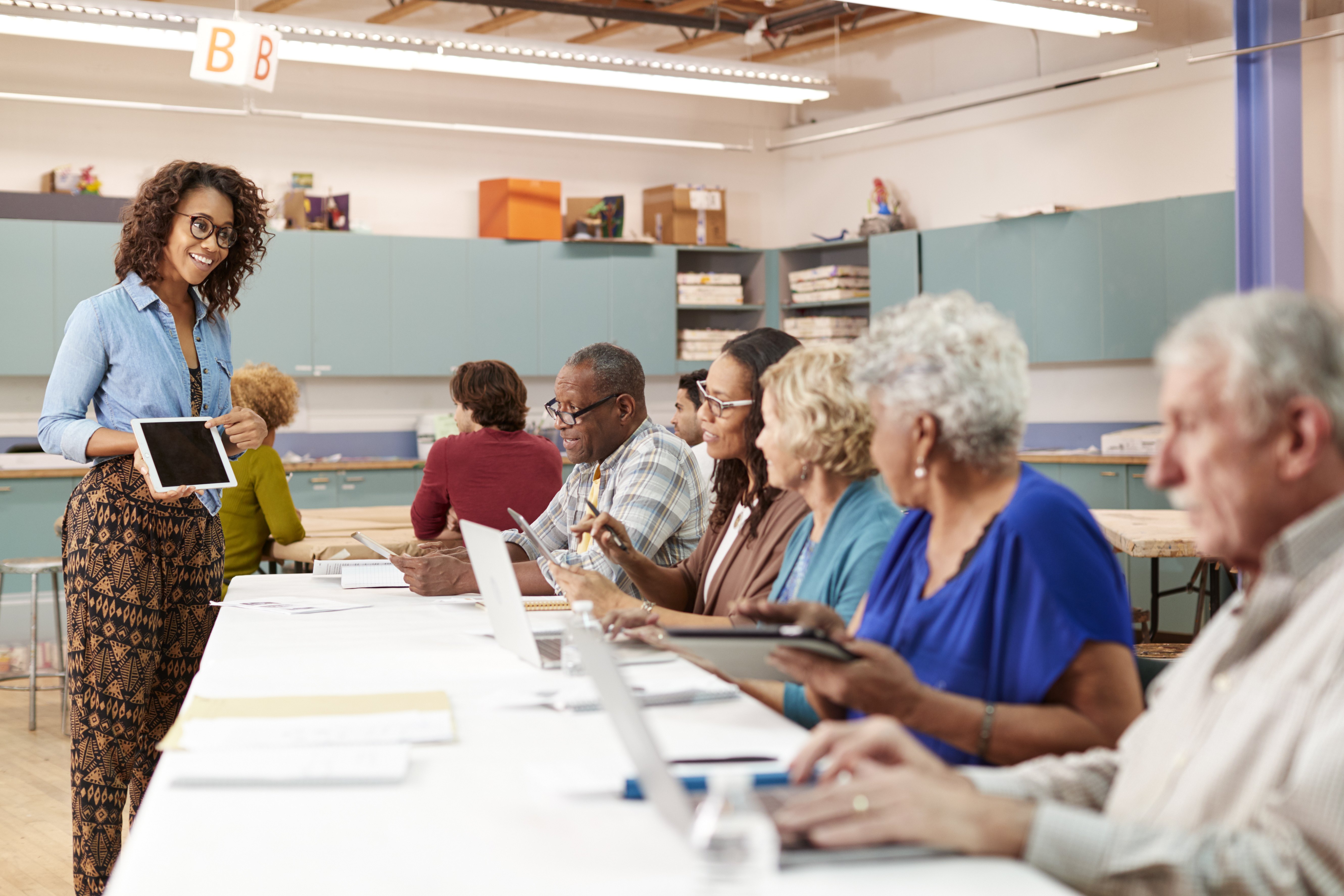 Woman with IPad teaching older adults