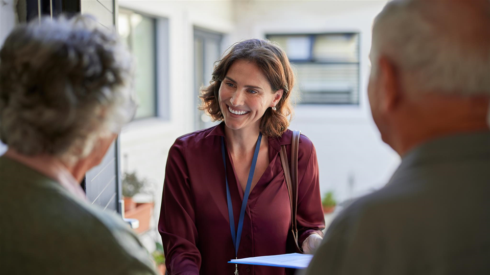 social worker talking with two older adults