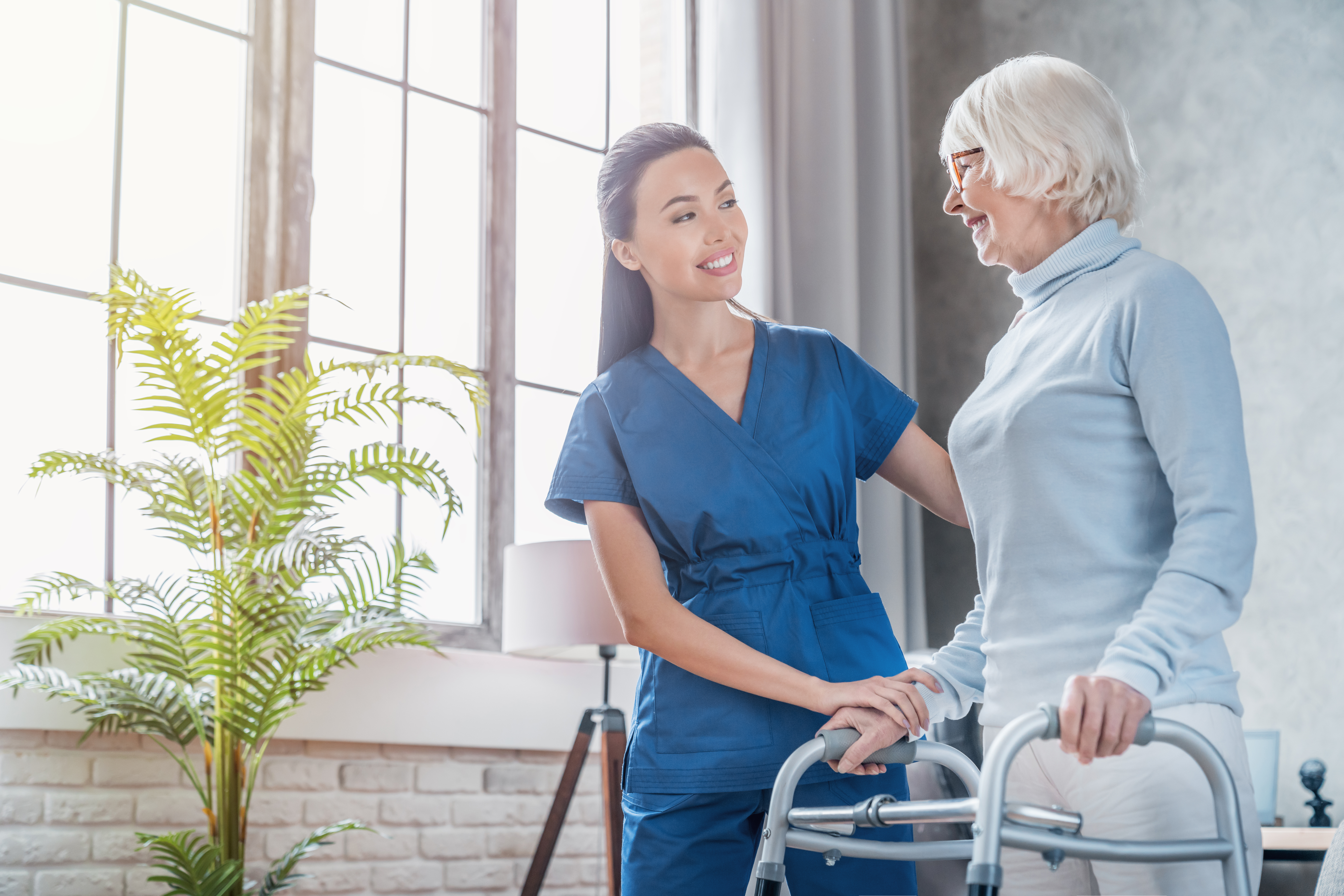 nurse helping an older woman with a walker